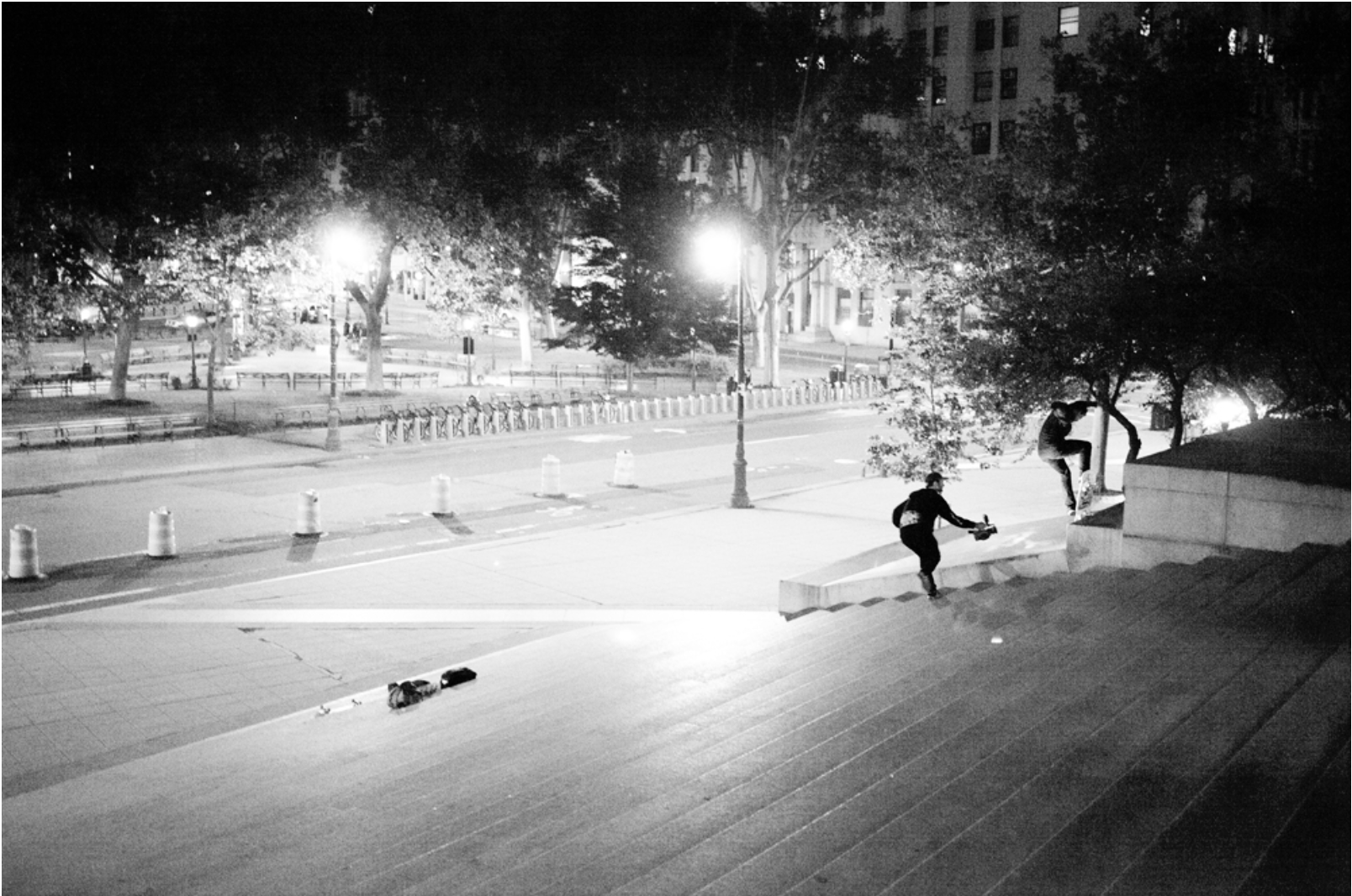 A black and white photo of a skateboarder at night.